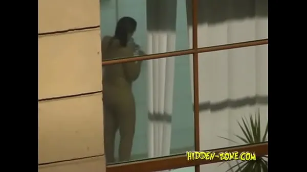 HD A girl washes in the shower, and we see her through the window energieclips